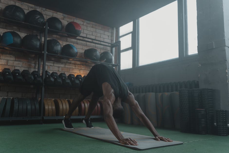 Man performing fitness workout on yoga mat in gym. Focus on strength and body posture